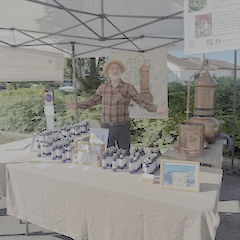 Stand Hydrolacîme à la Fête des Plantes de Vétraz-Monthoux, avec présentation d’hydrolats, d’huiles essentielles et d’un alambic en cuivre.